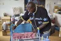 Een man hangt de was op een wasrek.