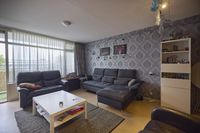 Algemene woonkamer met ornamentenprint op het behang en een zithoek.