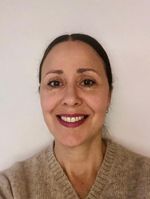 een vrouw met donker haar kijkt in camera