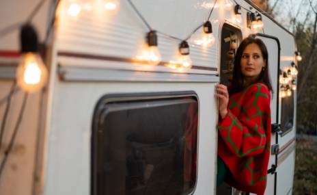 Frau steht am Wohnwagen