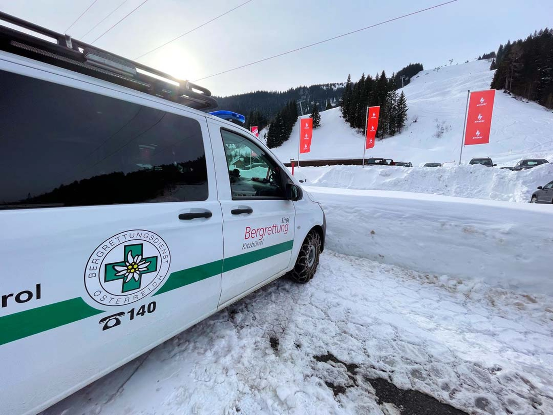 Einsatzfahrzeug der Bergrettung Kitzbühel vor einer steilen Abfahrtsstrecke im Skigebiet; zeigt den typischen Einsatzort, an dem die Bergrettung während des Hahnenkammrennens per websms zuverlässig SMS zur Koordination und schnellen Alarmierung versendet.