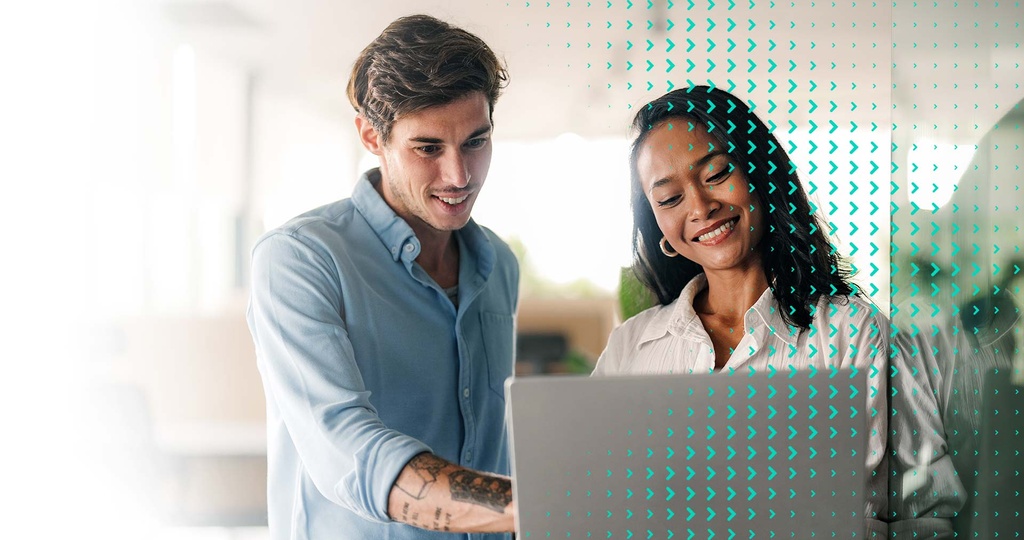 Zwei Personen arbeiten gemeinsam an einem Laptop und besprechen eine Integration der websms RCS API für Kommunikationsprozesse.