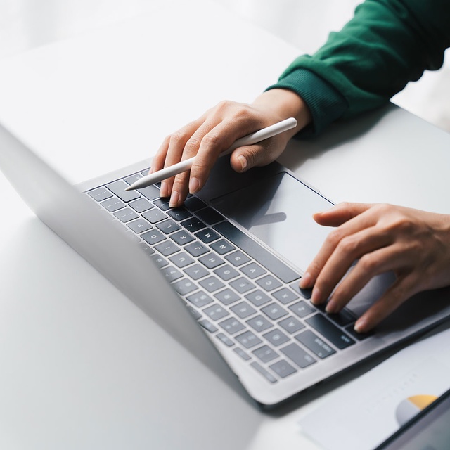 Person arbeitet an einem Laptop. Visualisierung der automatisierten Nachrichtenübertragung über die FTP‑Schnittstelle der websms SMS API.