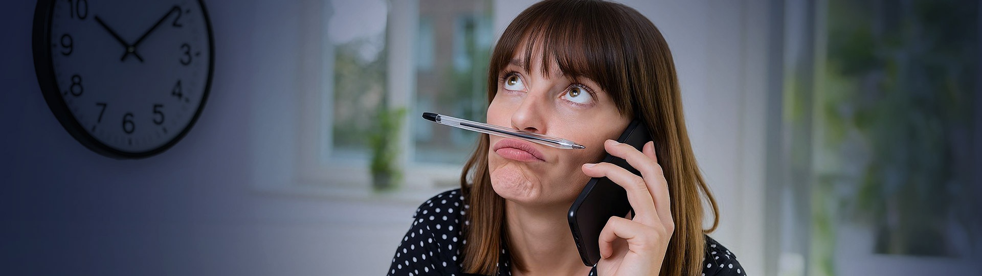 Eine gelangweilte Person versucht telefonisch ein Unternehmen zu kontaktieren. Das Bild symbolisiert klassischen Wartezeiten im Telefon-Support und die damit verbundenen manuellen Aufgaben, die durch KI-gestützte Voice- und SMS-Lösungen wie aiTel und websms automatisiert werden können.
