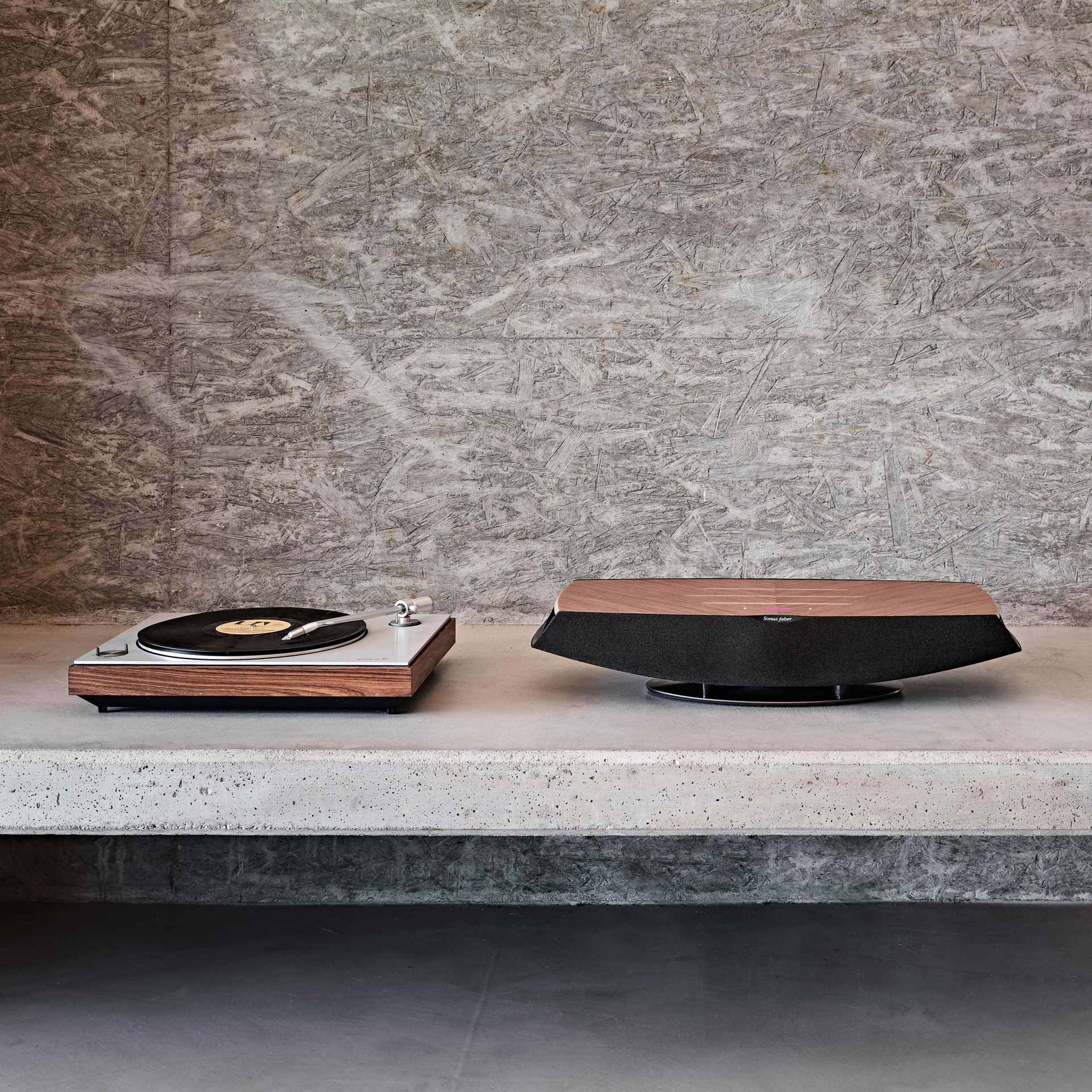 Sonus faber Omnia wireless bookshelf speaker in Walnut, paired with a turntable to showcase versatile connectivity.