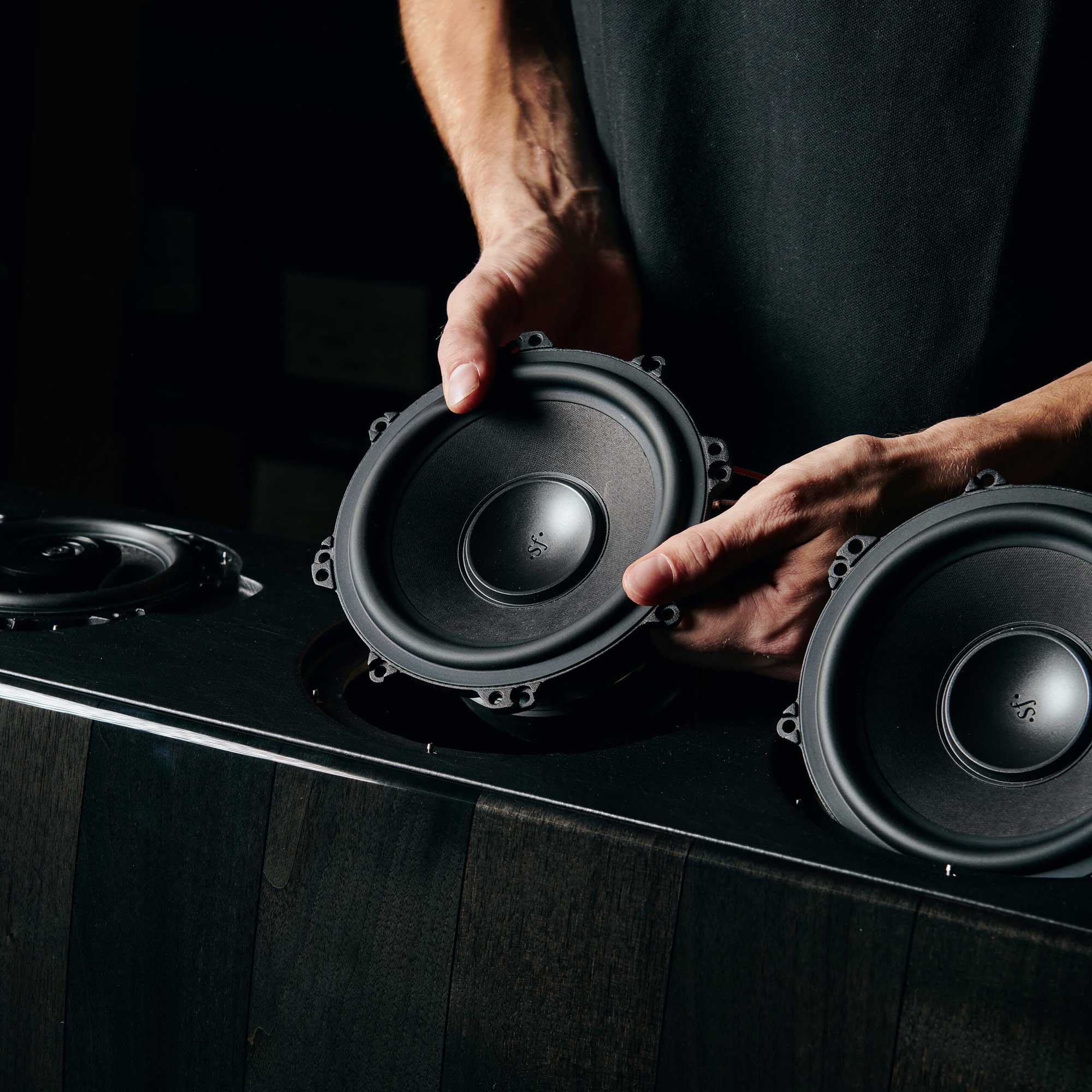 Sonus faber craftsman places woofers in Amati G5 floorstanding speaker, graphite finish, demonstrating meticulous assembly