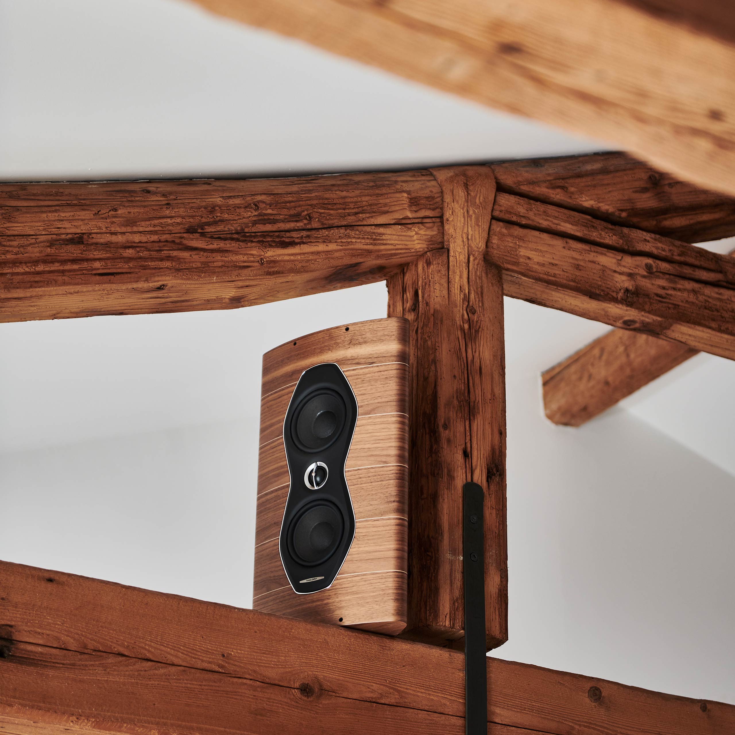 Sonus faber Olympica Nova W in Walnut Wood with Italian leather finishes seamlessly blending into ceiling wood beams.