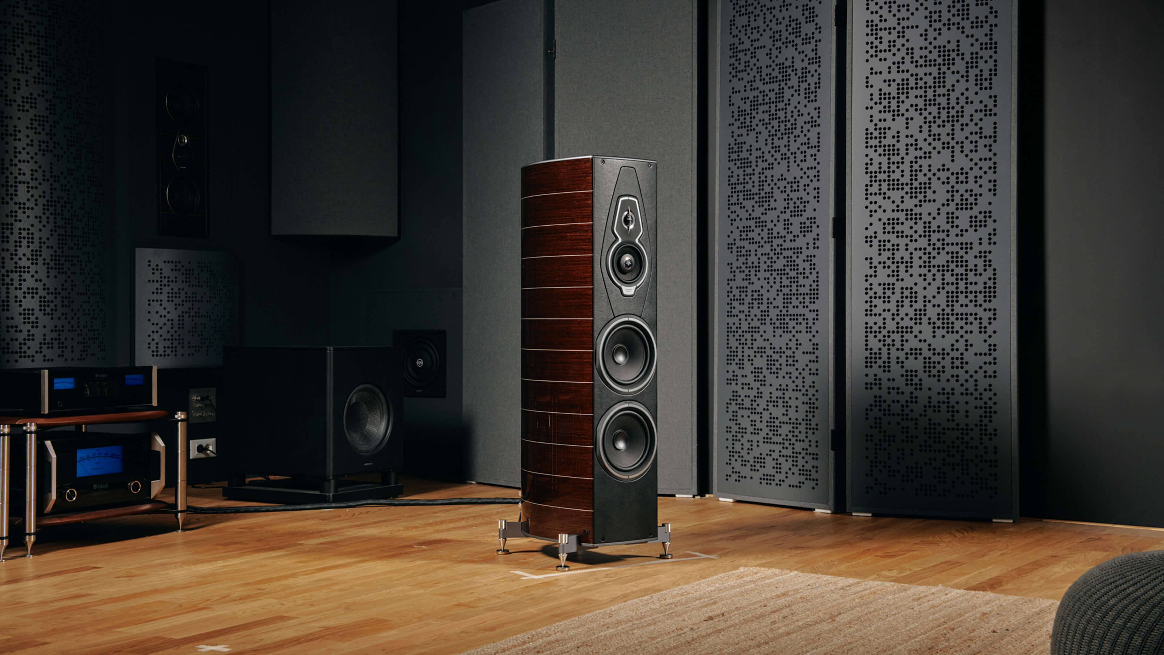 Sonus faber Amati G5 floorstanding speaker gracefully placed next to a fireplace, creating a cozy and elegant ambiance.