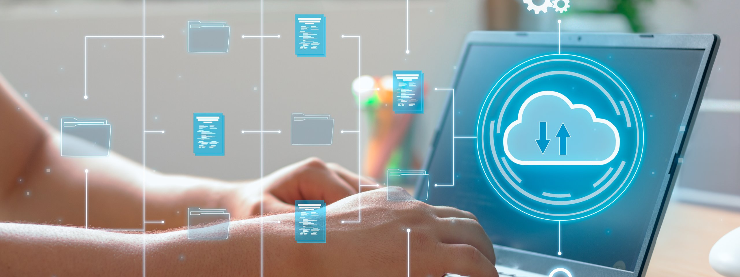 Hands typing on a laptop with digital icons of folders, a cloud, and gears, representing data storage and cloud computing.