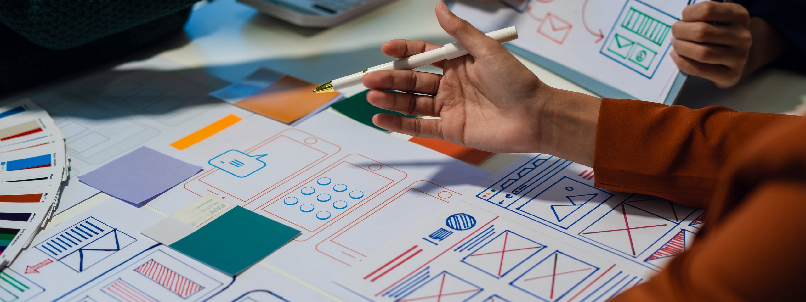 UX-Designer arbeiten gemeinsam an Wireframes und Farbschemata für eine mobile App.