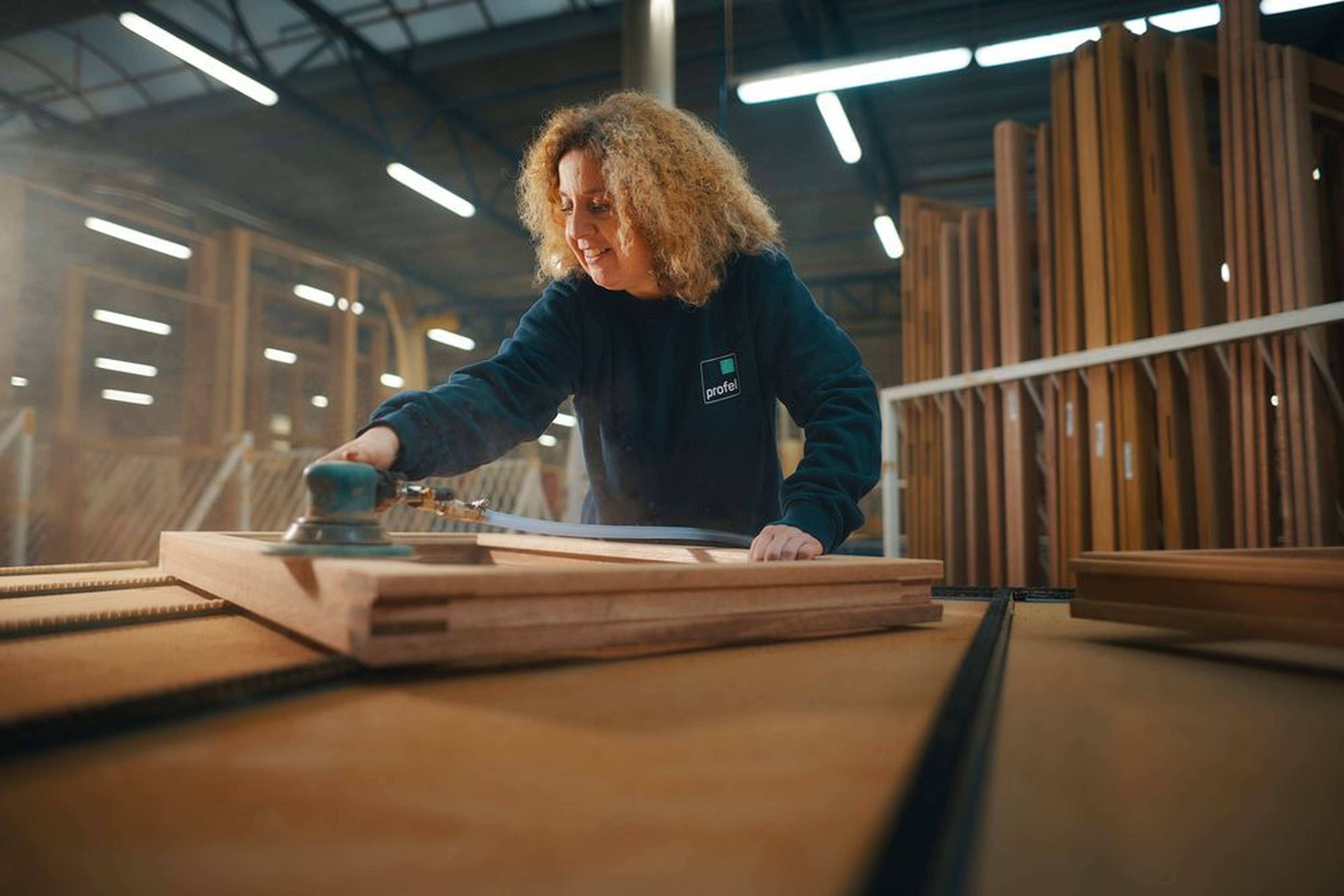 Membre du personnel de Profel Group au travail dans le hall de production bois à Pelt, Belgique