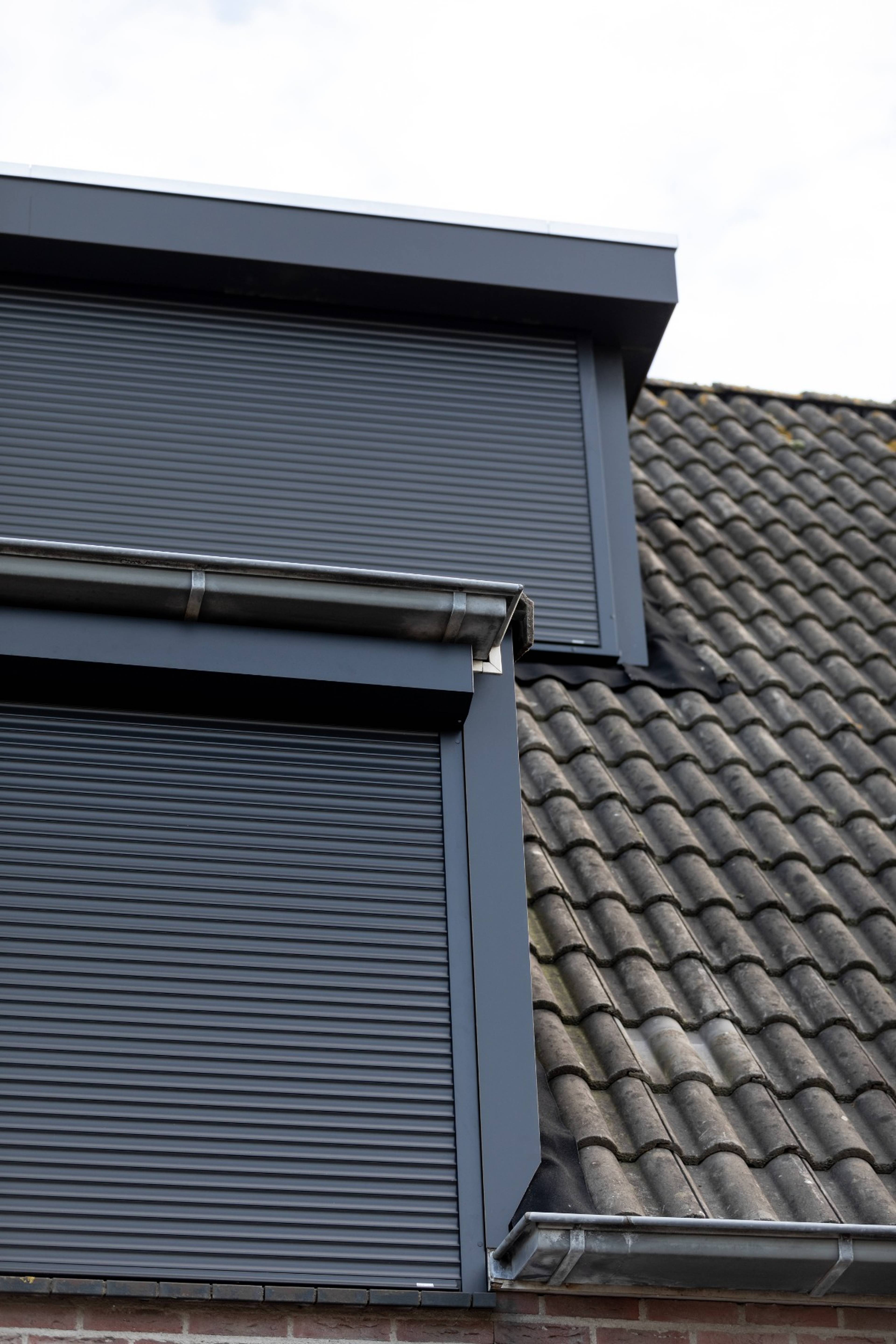 Vue extérieure de volets roulants noirs sur des fenêtres de toit noires de Profel