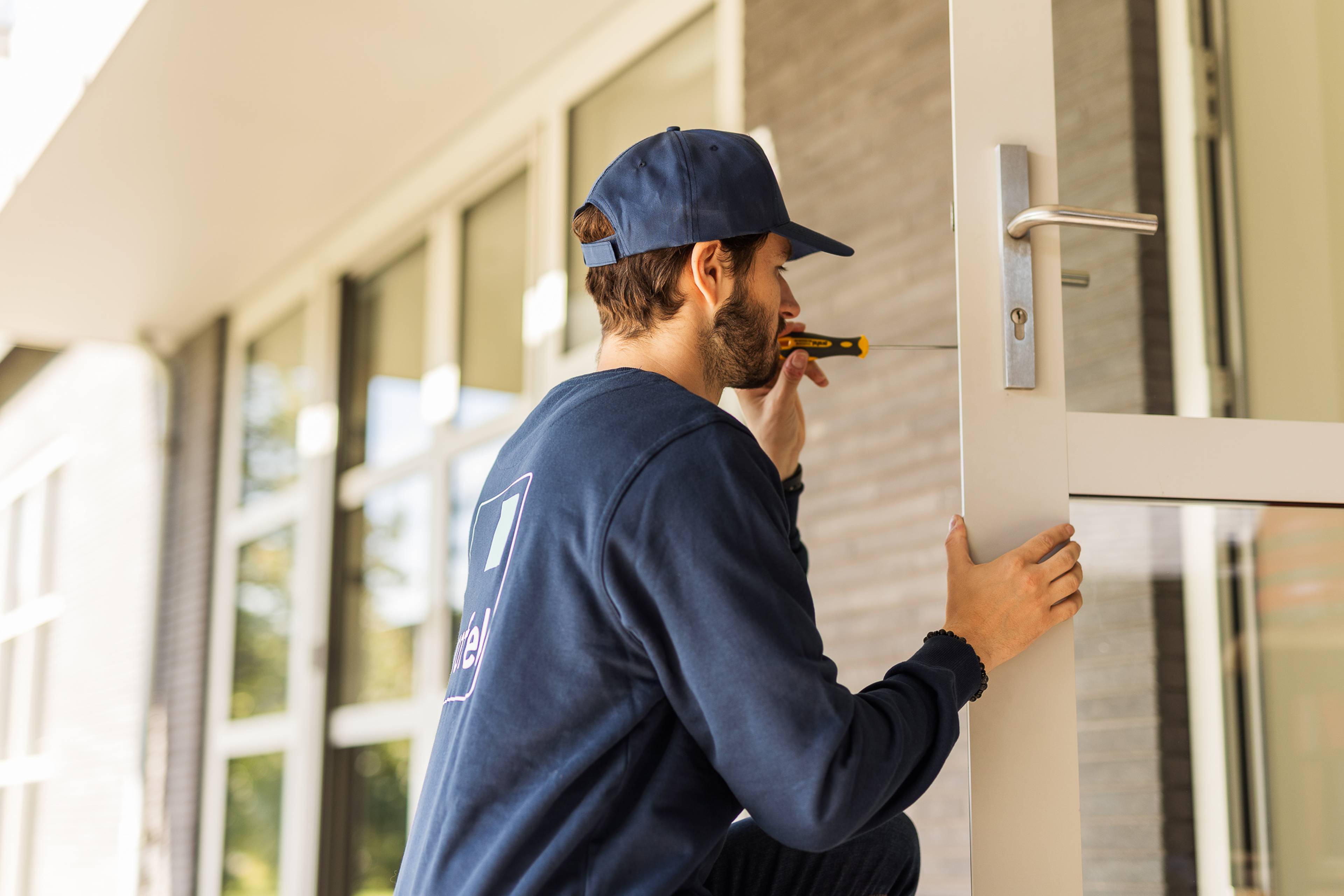 Un expert Profel qui répare une porte blanche de Profel