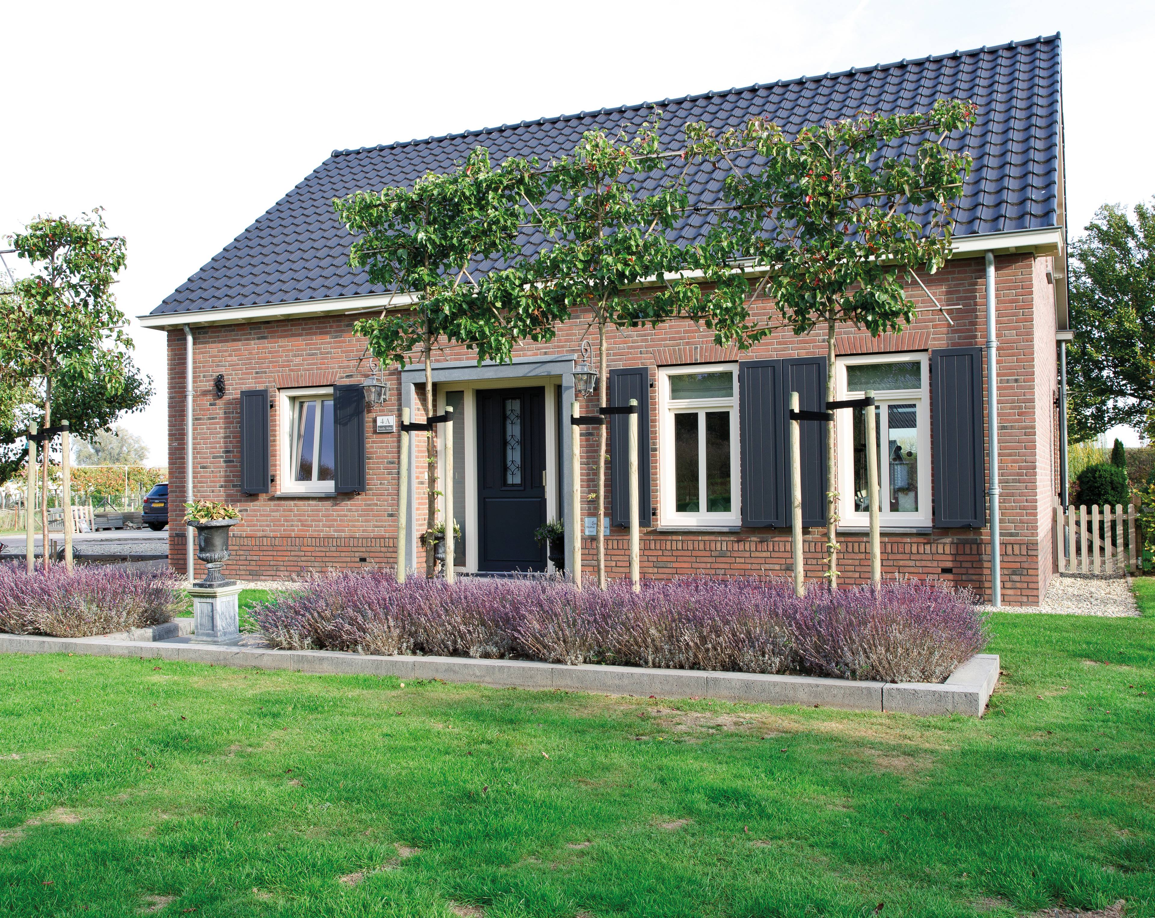 Oude kozijnen in klassieke woning vervangen door witte kunststof blok kozijnen met blauwe sierluiken