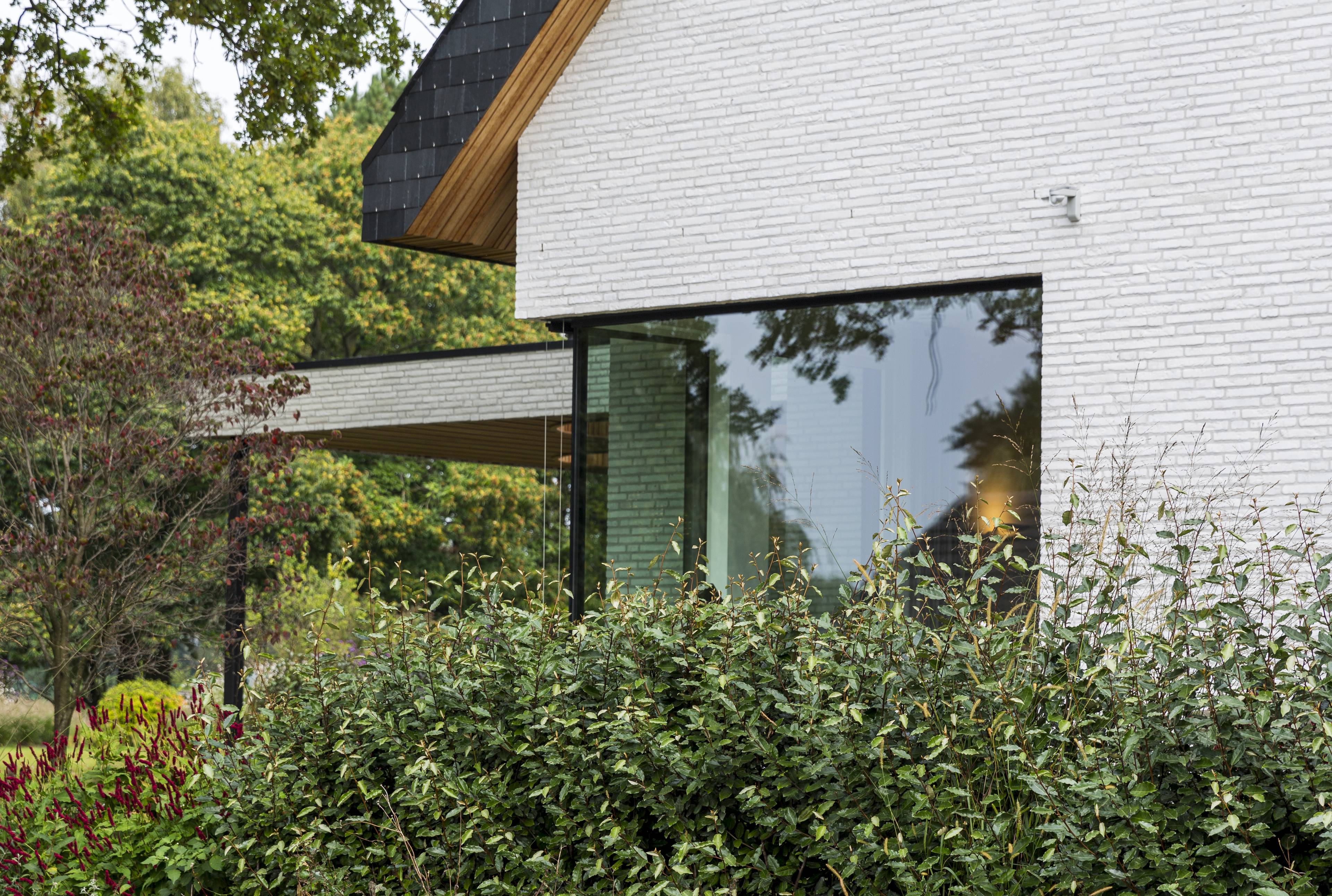 Maison moderne en briques blanches avec des châssis en aluminium noirs fins et minimalistes de Profel de style moderne
