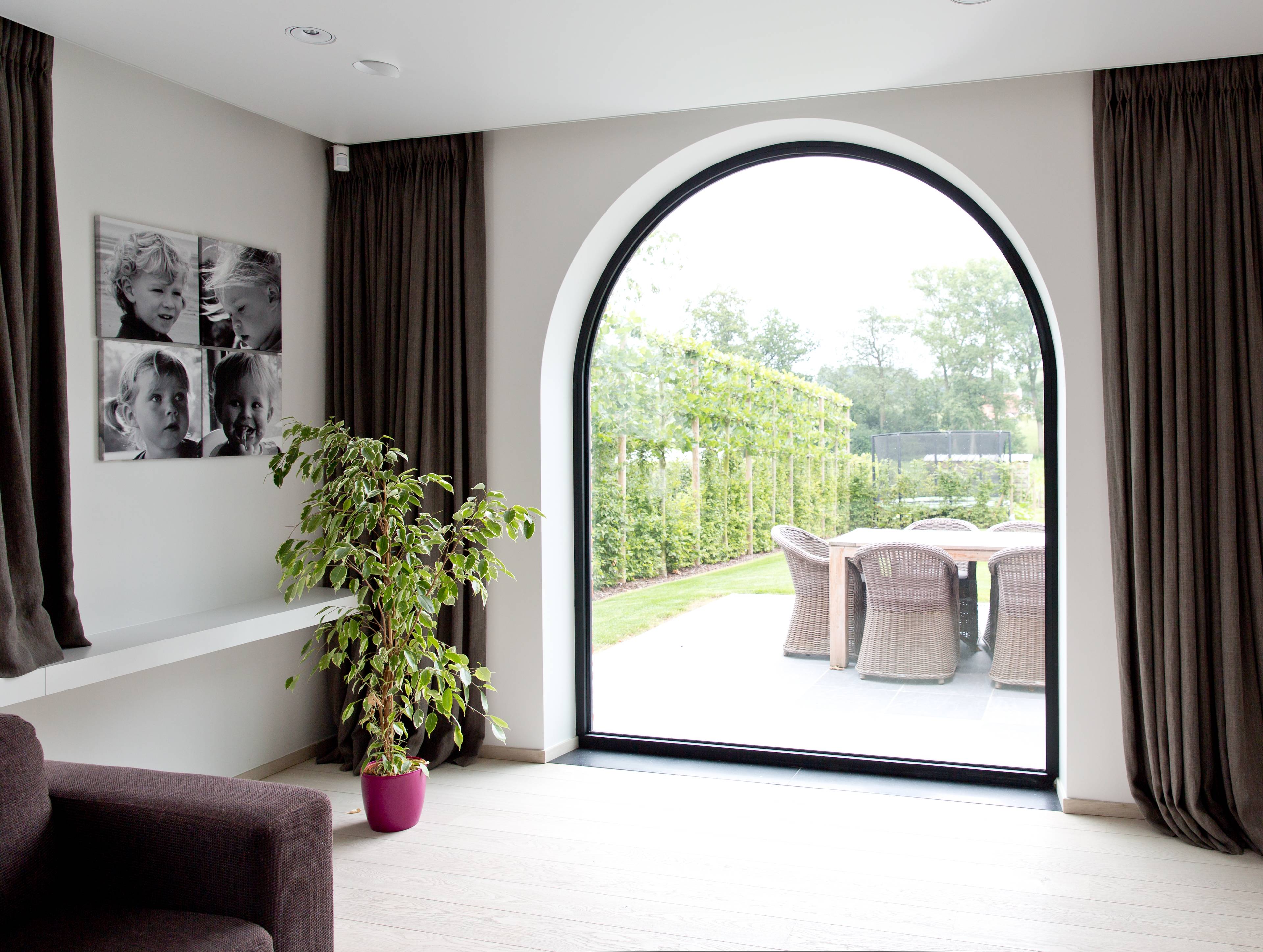 Vue intérieure d’une fenêtre en aluminium noir moderne et épurée de Profel avec forme cintrée.