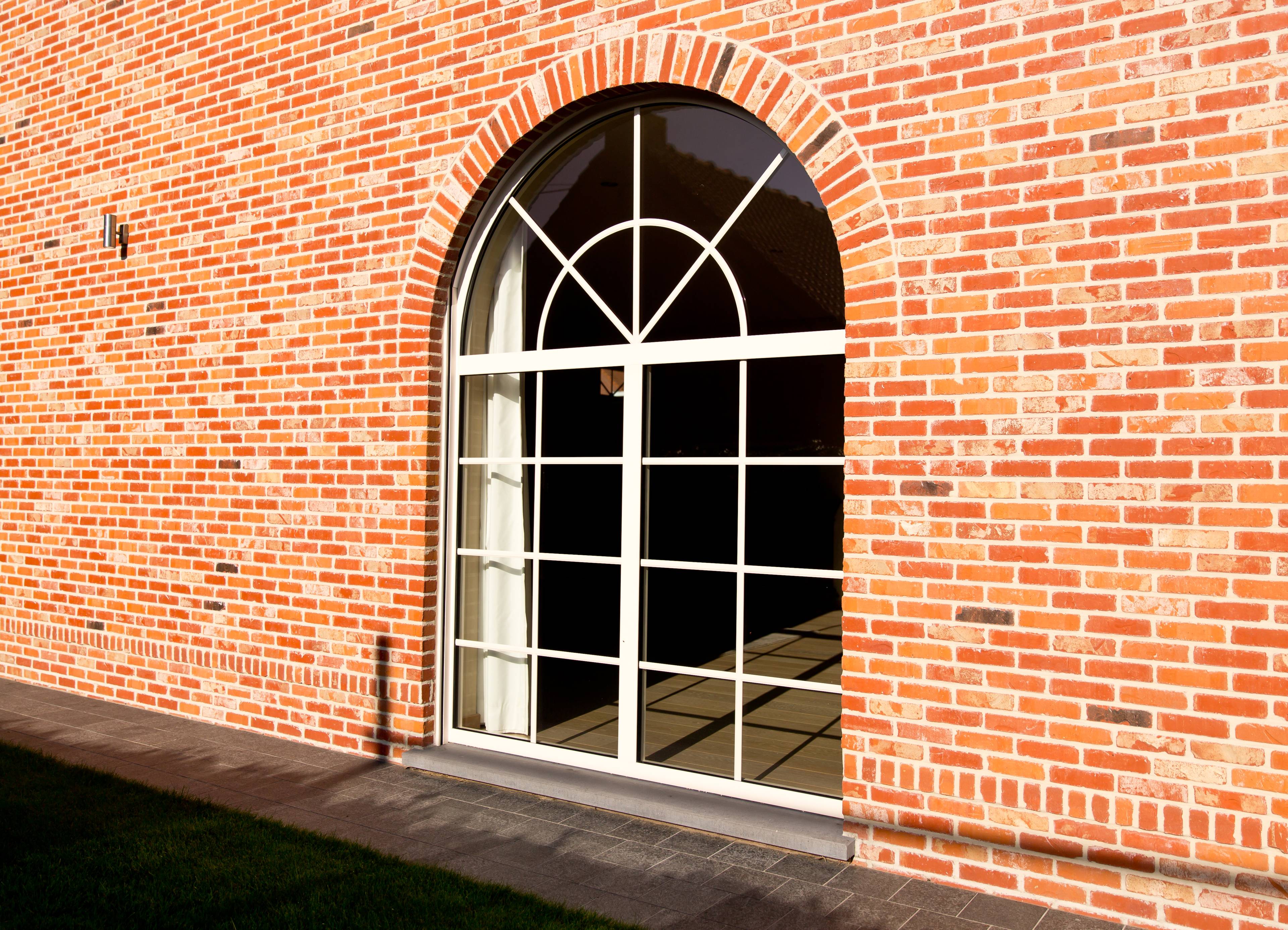 Maison orange avec un grand châssis intemporel en aluminium blanc de Profel, à croisillons
