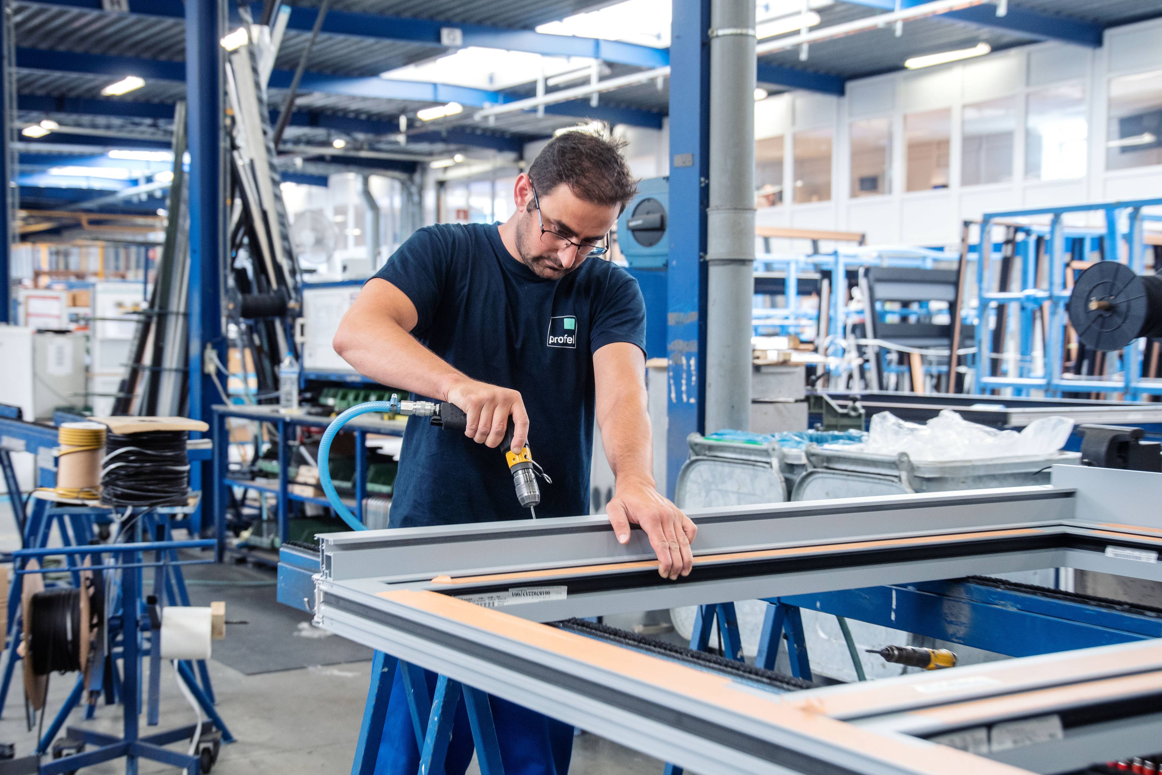 Un artisan Profel assemble des fenêtres en PVC Profel dans l'atelier de production à Pelt, en Belgique