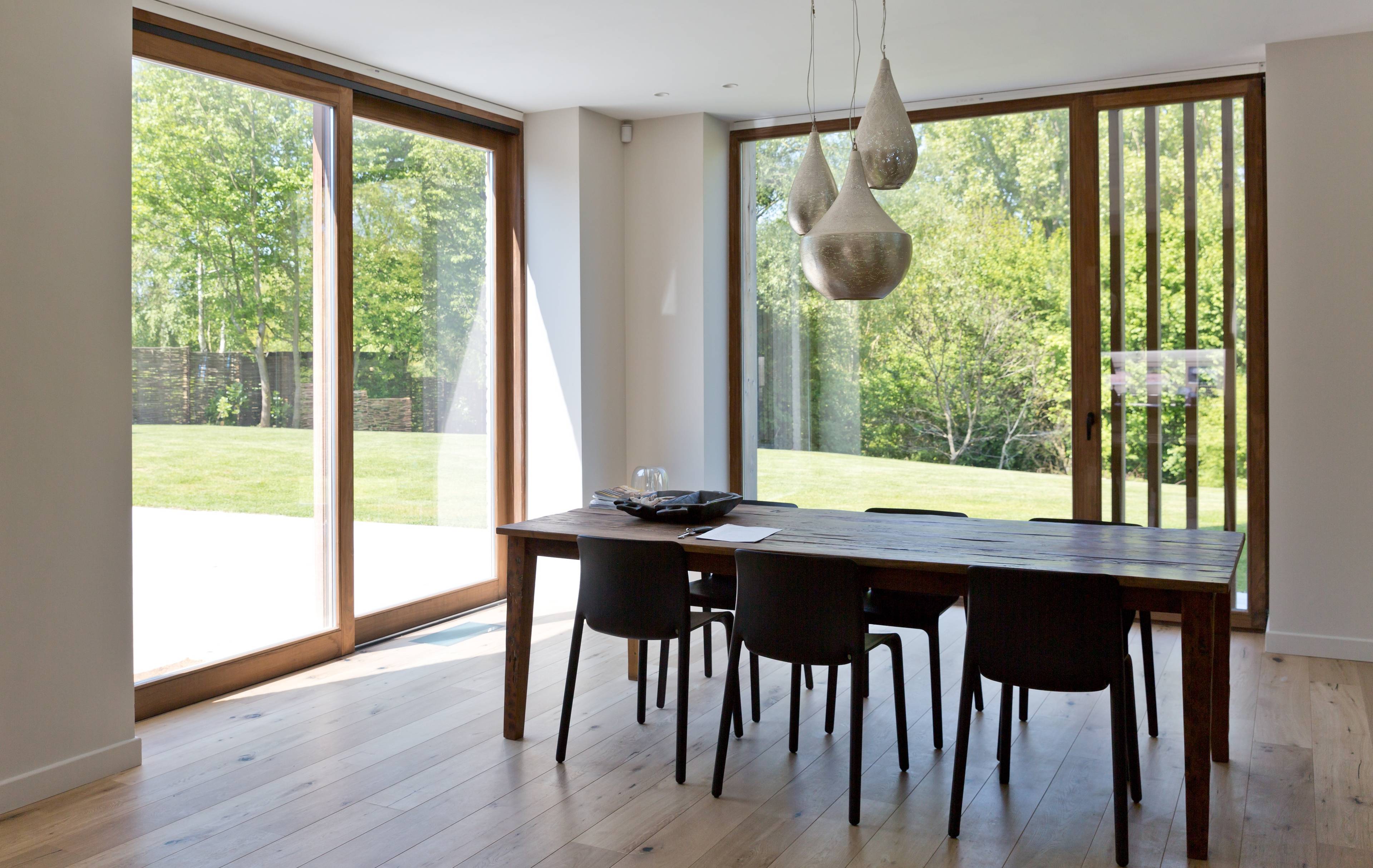 Vue intérieure de la salle à manger avec de grands châssis en bois modernes de Profel
