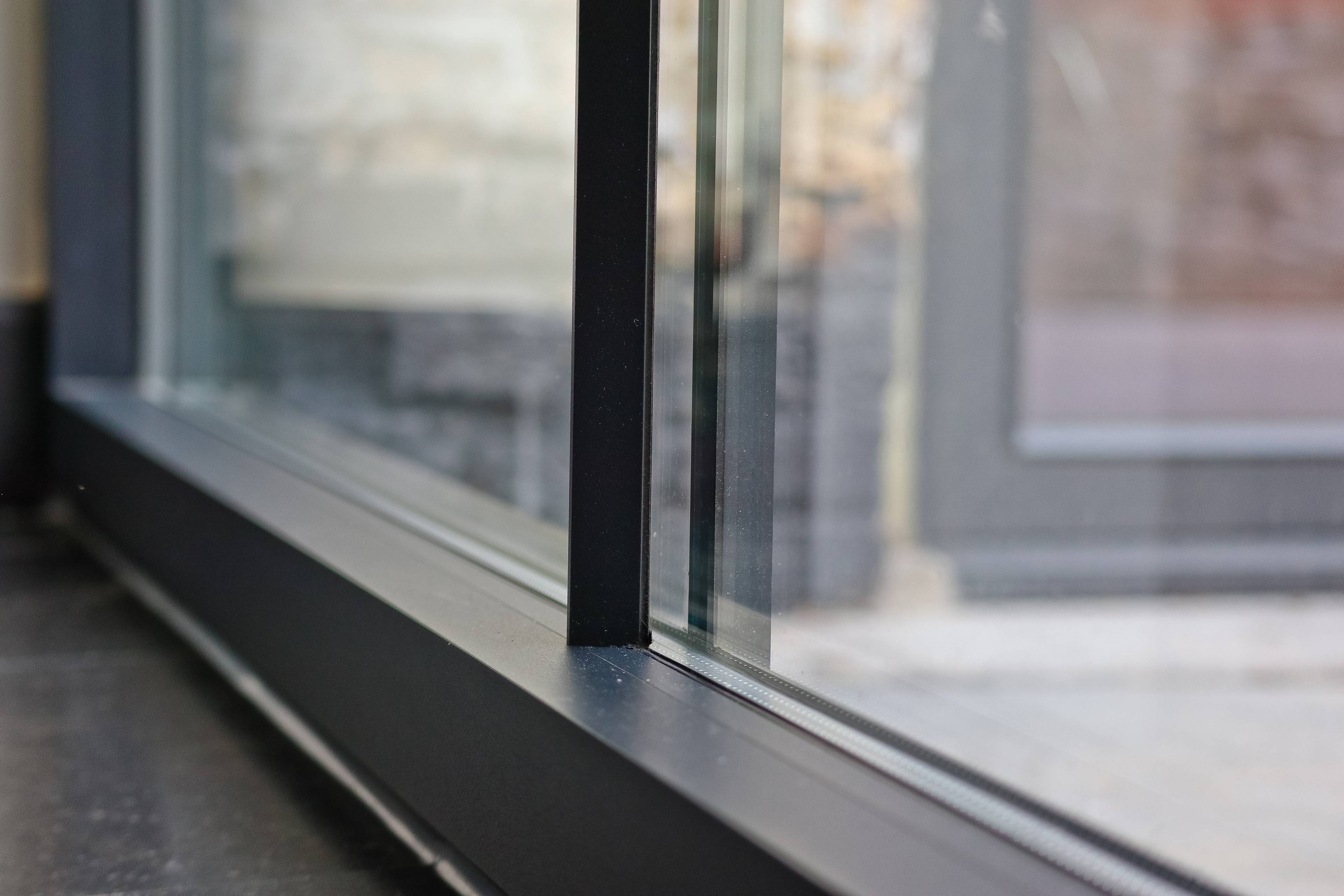 Close-up de châssis noirs de style rural en aluminium avec croisillons sur le vitrage de Profel