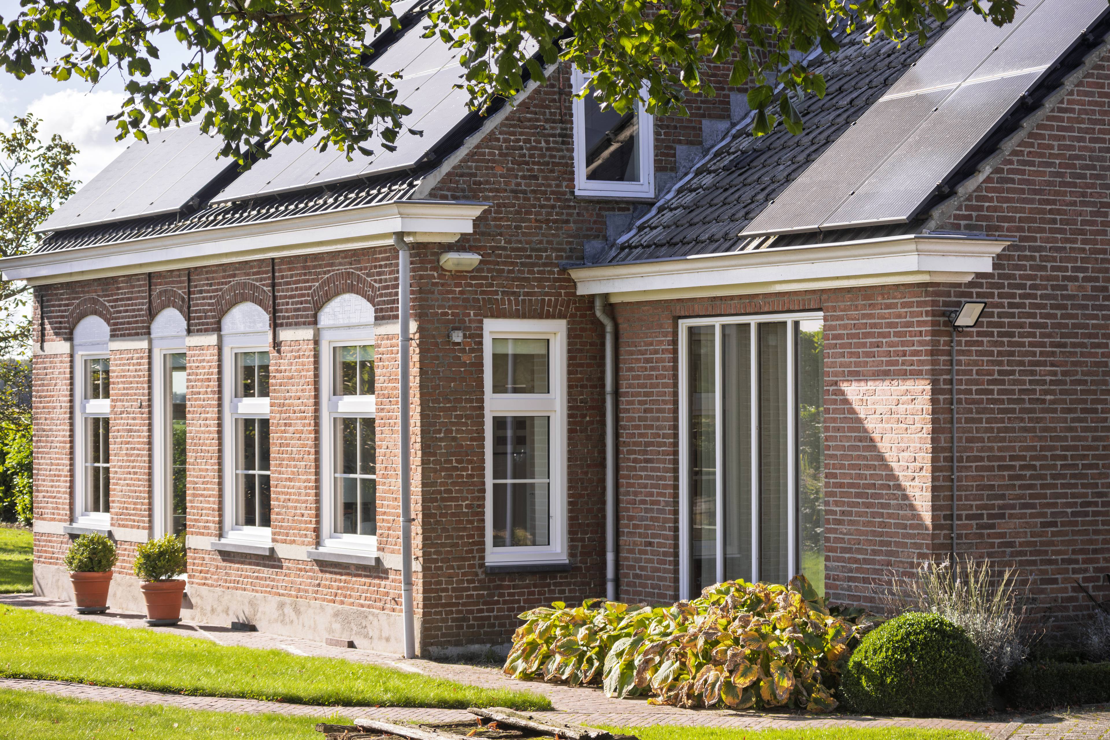 Klassieke woning met nieuwe witte kunststof kozijnen met kruisverdelingen
