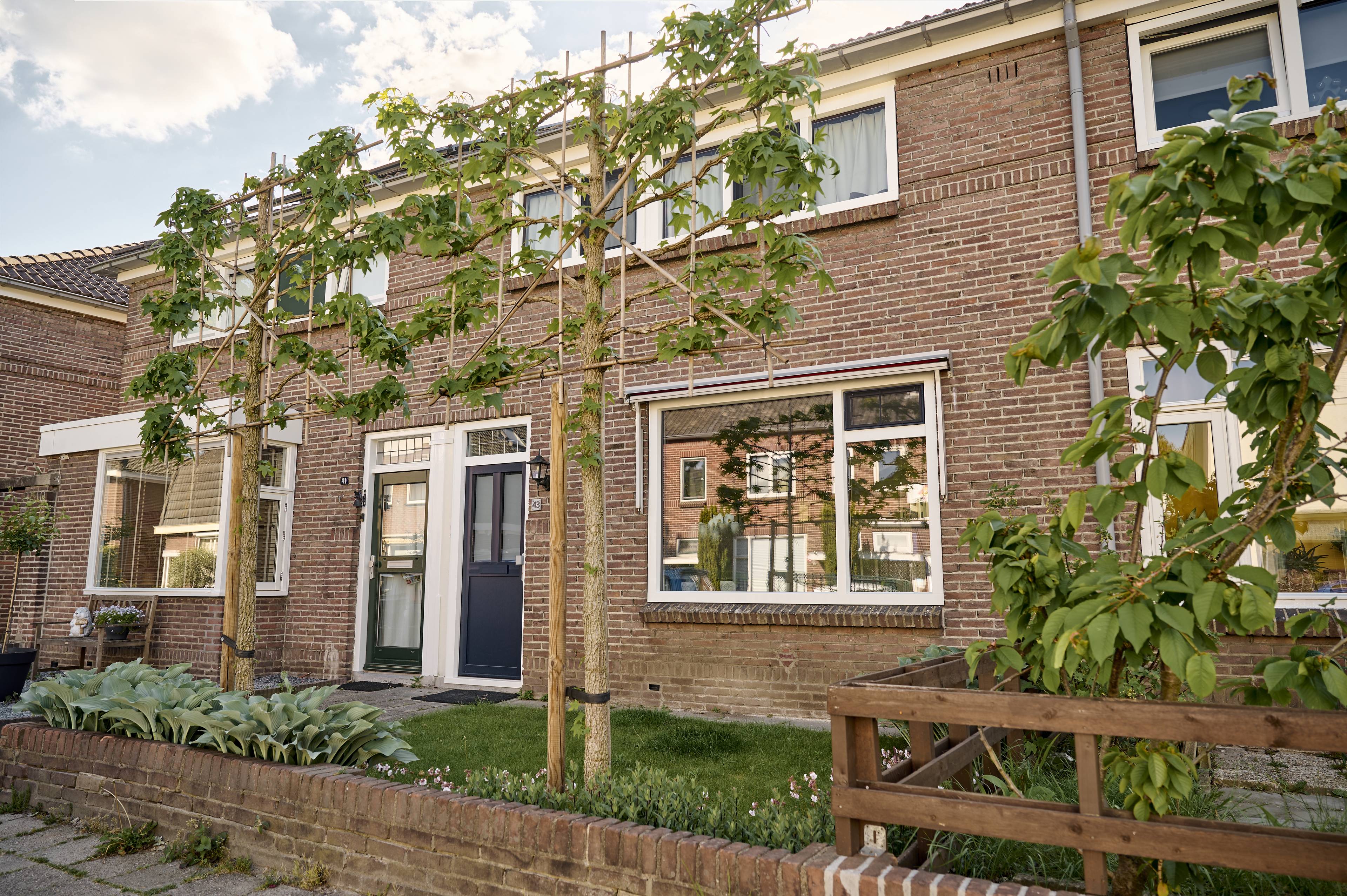 Klassieke gerenoveerde woning met nieuwe tijdloze witte kunststof blok kozijnen en blauwe voordeur