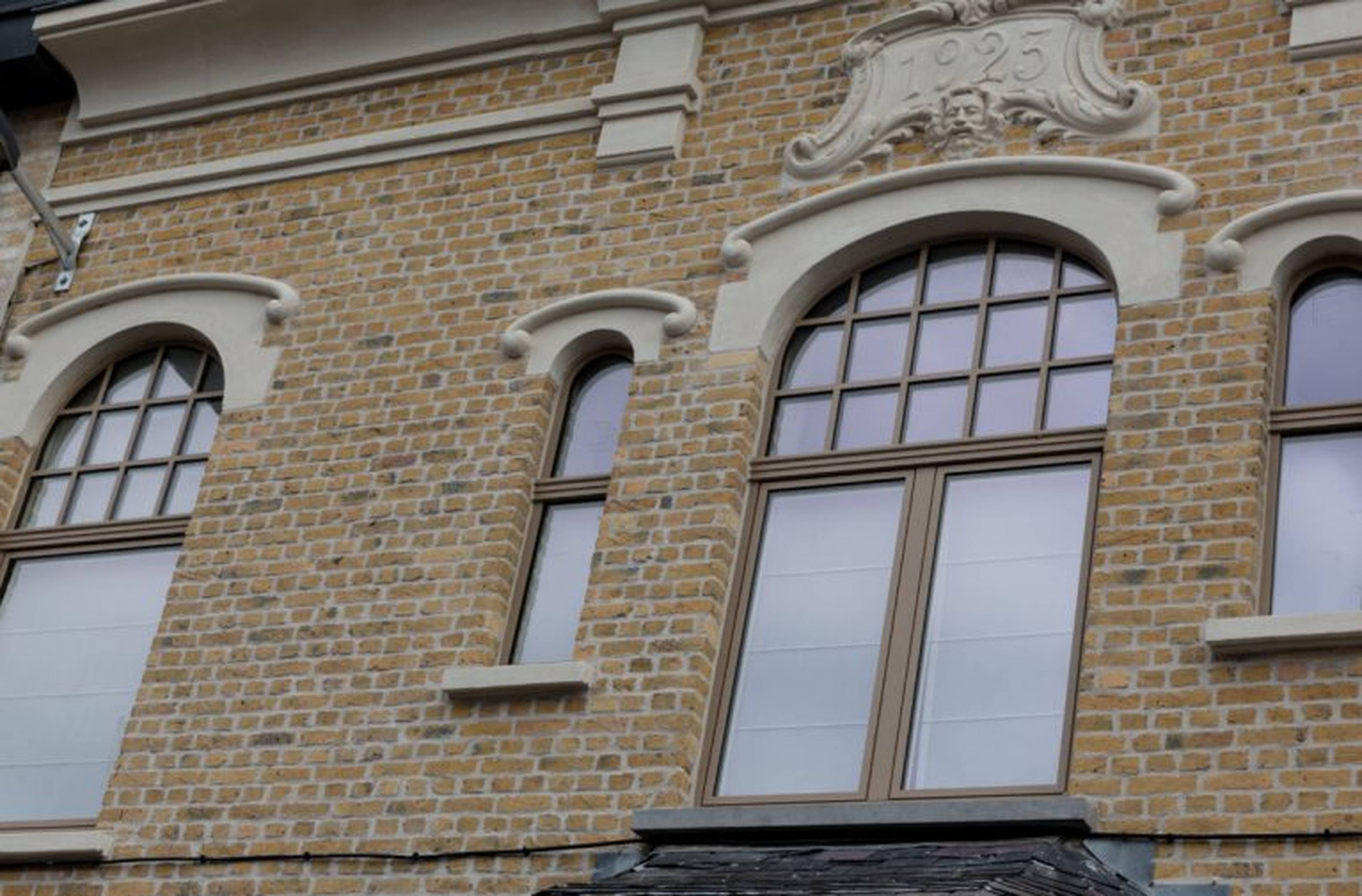 Maison authentique avec des fenêtres classiques en aluminium bronze à croisillons