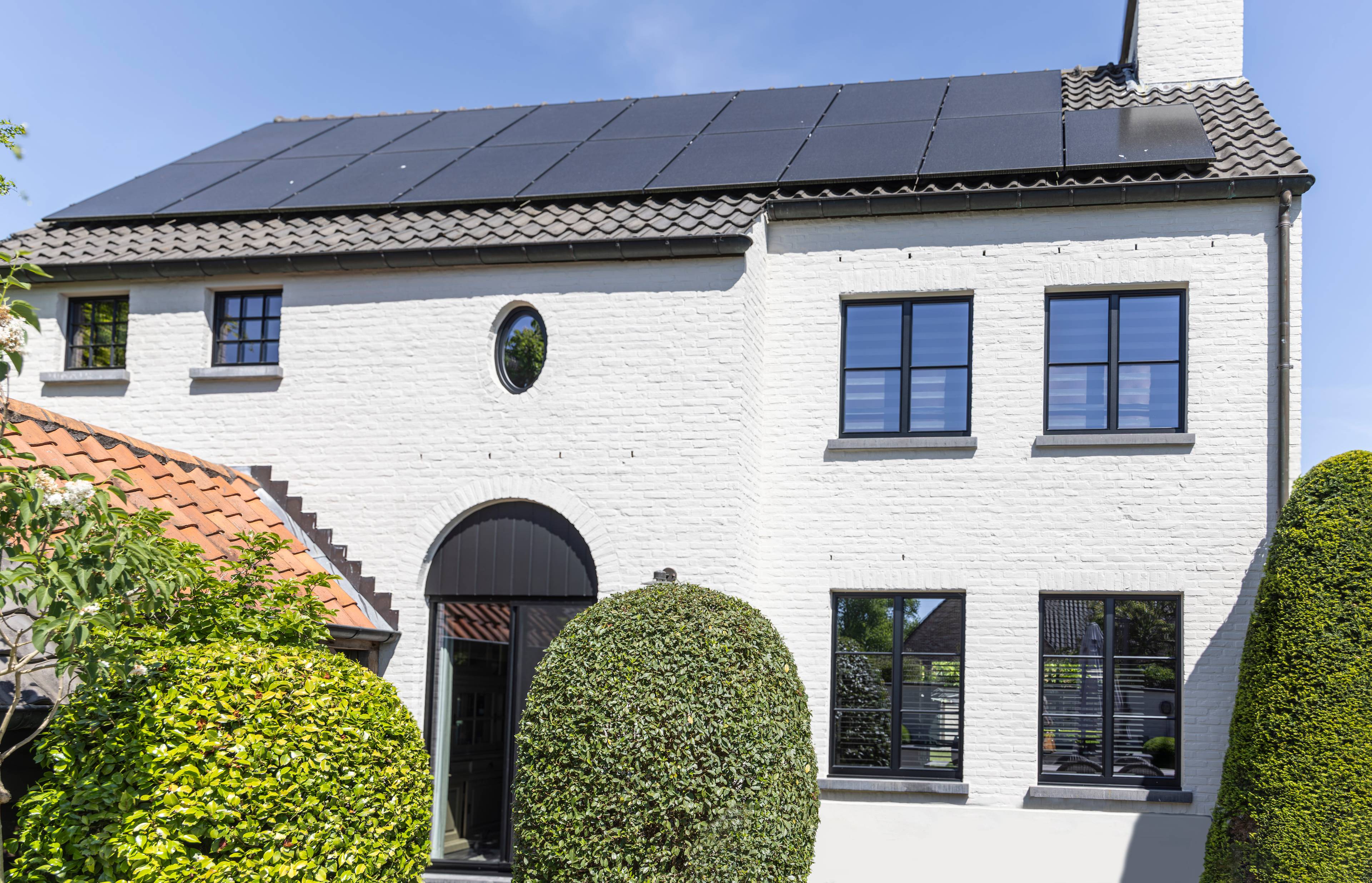 Gerenoveerde woning met strakke zwarte aluminium ramen met kruisverdelingen