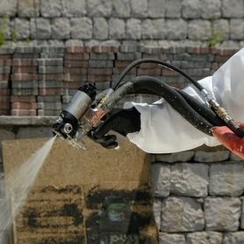 Stříkací pistole v provozu u rekonstrukce stavby.