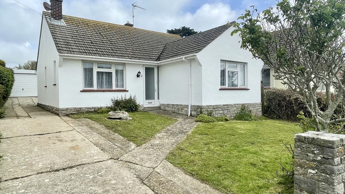 White bungalow and driveway and lawn area