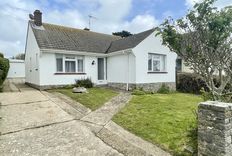 White bungalow and driveway and lawn area