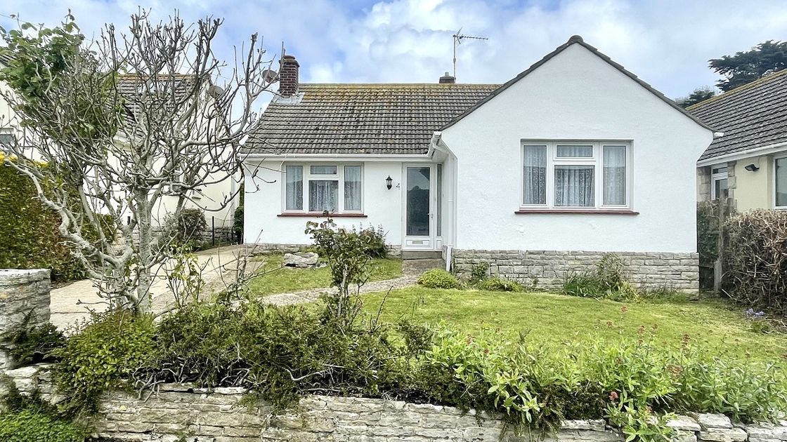 White bungalow and driveway and lawn area