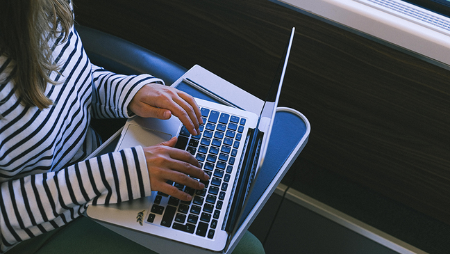 Woman working on a laptop while traveling by train