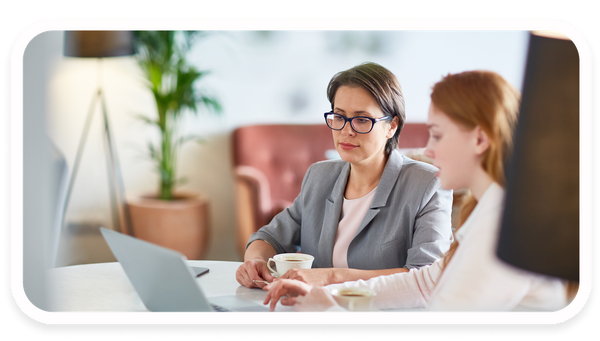 Twee vrouwen in een consultgesprek met een laptop.