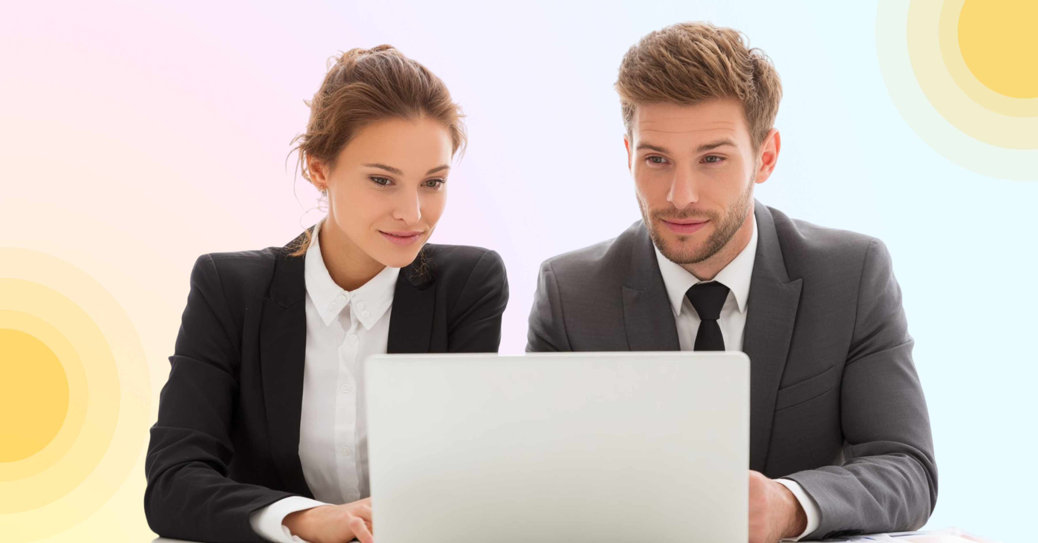 Woman and man in business attire sitting in front of a laptop