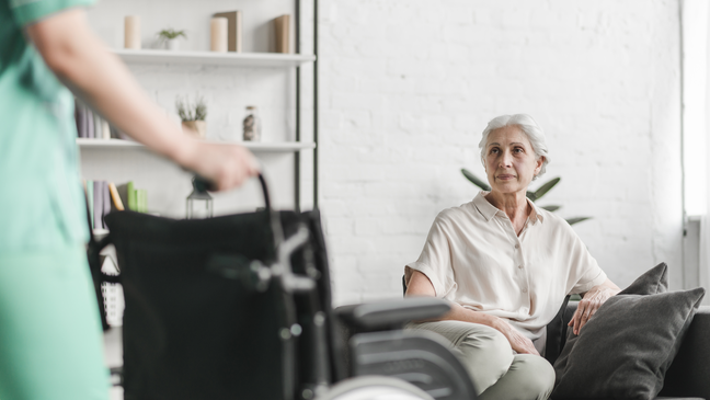 Elderly woman in a care facility visited by a caregiver