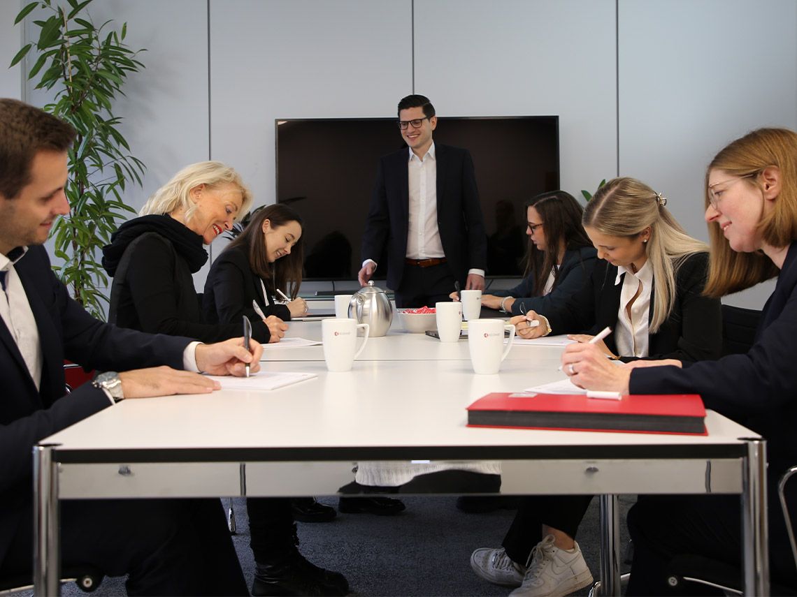 Mehr-über-das-Unternehmen ECOVIS KSO Gruppe am Schreibtisch in Besprechung