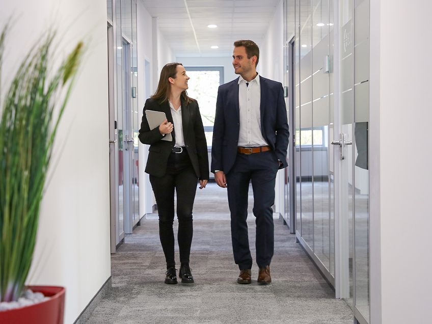 Gespräch-in-Flur-Young-Professionals bei ECOVIS KSO Mann und Frau laufen