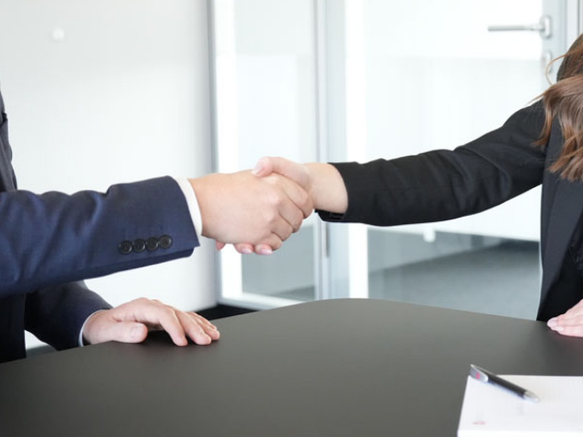 Handshake Mann und Frau in Business Outfits