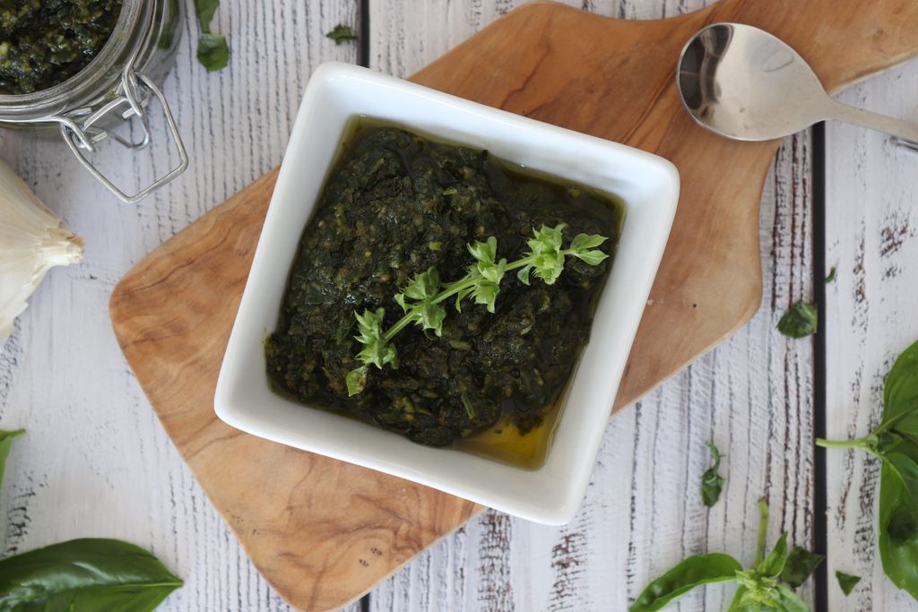 Basilikum-Pesto Basilikum-Pesto in einer Schüssel auf einem Brett