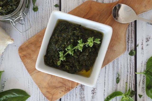 Basilikum-Pesto Basilikum-Pesto in einer Schüssel auf einem Brett