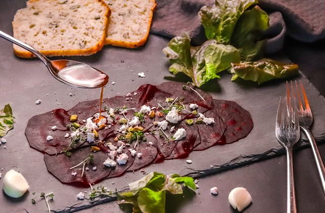 Rote Rüben Carpaccio Rote Rüben Carpaccio auf einer Steinplatte