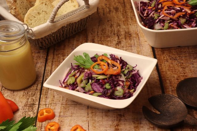 Rohkostsalat mit Honig-Senfdressing Rohkostsalat auf einem Teller mit Brot und Dressing