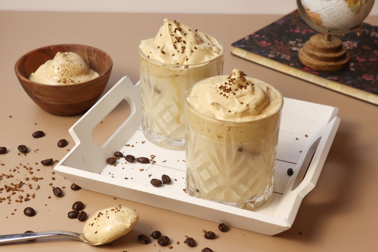 Dalgona-Kaffee in einem Glas auf einem Tablett