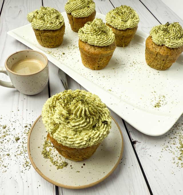 Zucchini-Cupcakes mit Kürbiskernfrosting auf einem Teller mit Kaffee