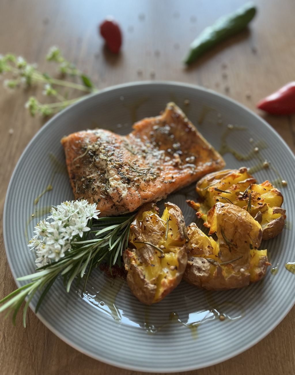 Lachsforellenfilet mit Honig-Gewürzsauce und Smashkartoffeln Lachsforellenfilet mit Smashkartoffeln auf einem Teller