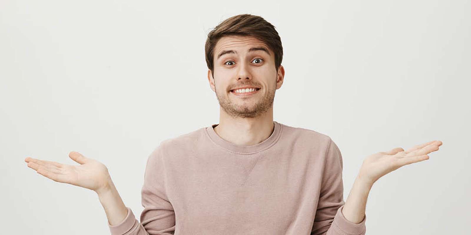 Young male student shrugging shoulders