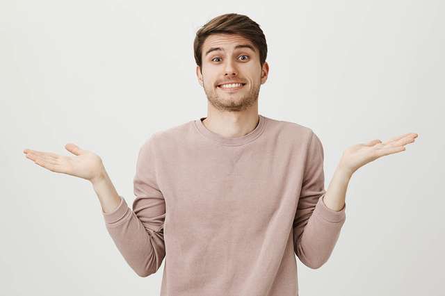 Young male student shrugging shoulders