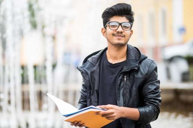 Young student apprentice with open notes/books outside