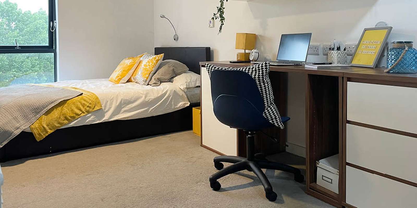 Bed, desk and laptop in student accommodation